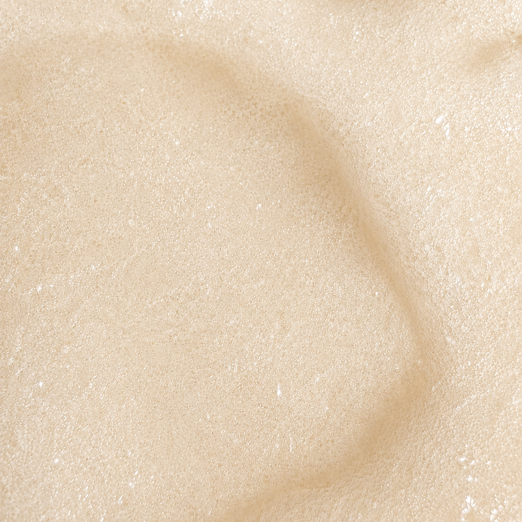 Macro view of Rivahna Vanilla Cream Slime Sugar Scrub texture featuring a soft creamy exfoliating formula with fine sugar granules for gentle body exfoliation and radiant skin.